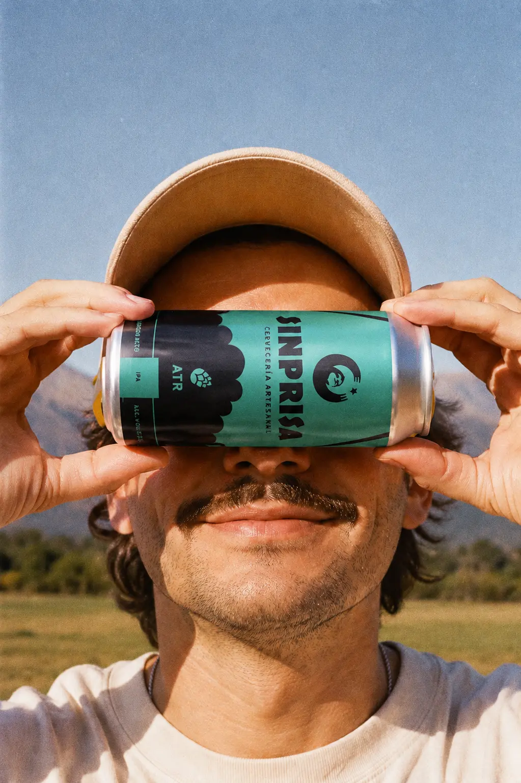 Persona sosteniendo una lata de Sinprisa contra el cielo, foto de estilo de vida