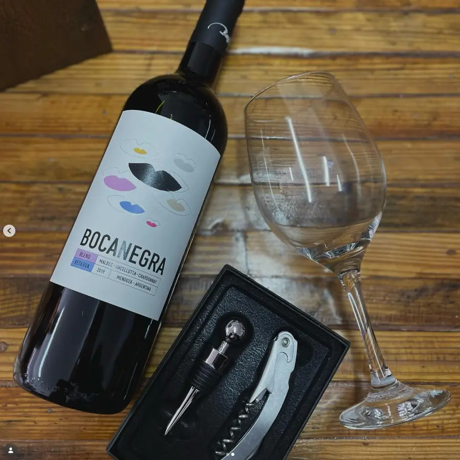 Botella de Bocanegra junto a una copa y un sacacorchos sobre madera