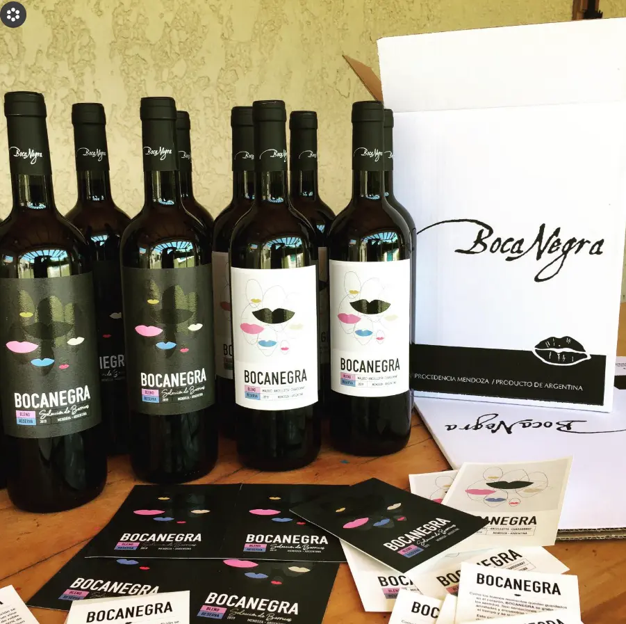 Botellas Bocanegra junto a la caja de envío con firma caligráfica y tarjetas impresas